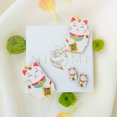 Onnea tuovat Onnenkissa 'Maneki Neko' nappikorvakorut. Maneki neko 招き猫, eli onnenkissa on hyvin perinteinen näkymä japanilaisessa symboliikassa. Sen on ajateltu tuovan onnea omistajalleen. Onnenkissat ovat täydelliset sinulle, mikäli pidät japanilaisesta symboliikasta.   Nämä uniikit Onnenkissa nappikorvakorut sopivat erinomaisesti arkikäyttöön! Tässä on myös jollekin Japanin kulttuurin ihailijalle erityinen lahjaidea! Rakkkaudella käsintehty Suomessa.